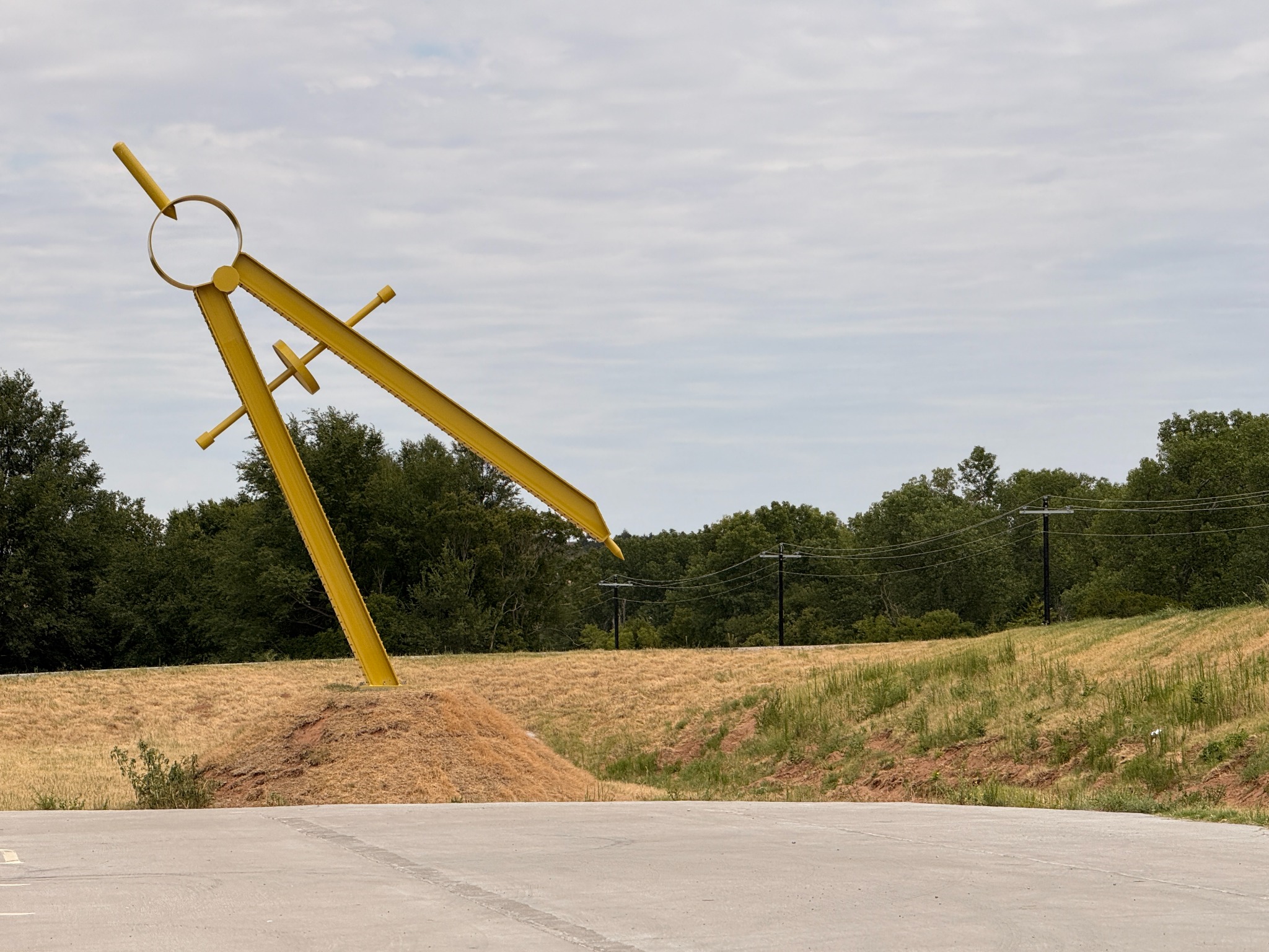 A giant yellow compass sculpture along Route 66.