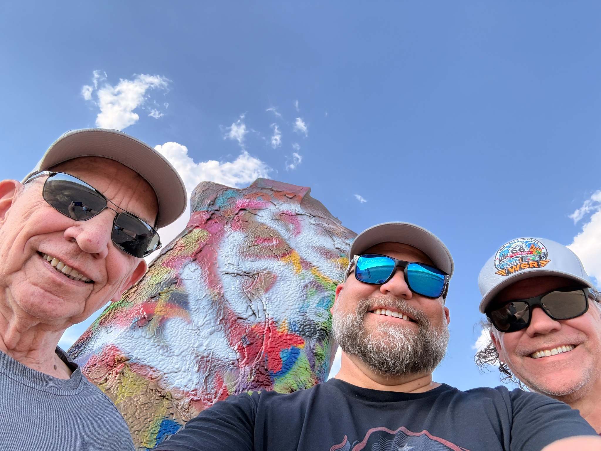 A team selfie beside a painted Cadillac.