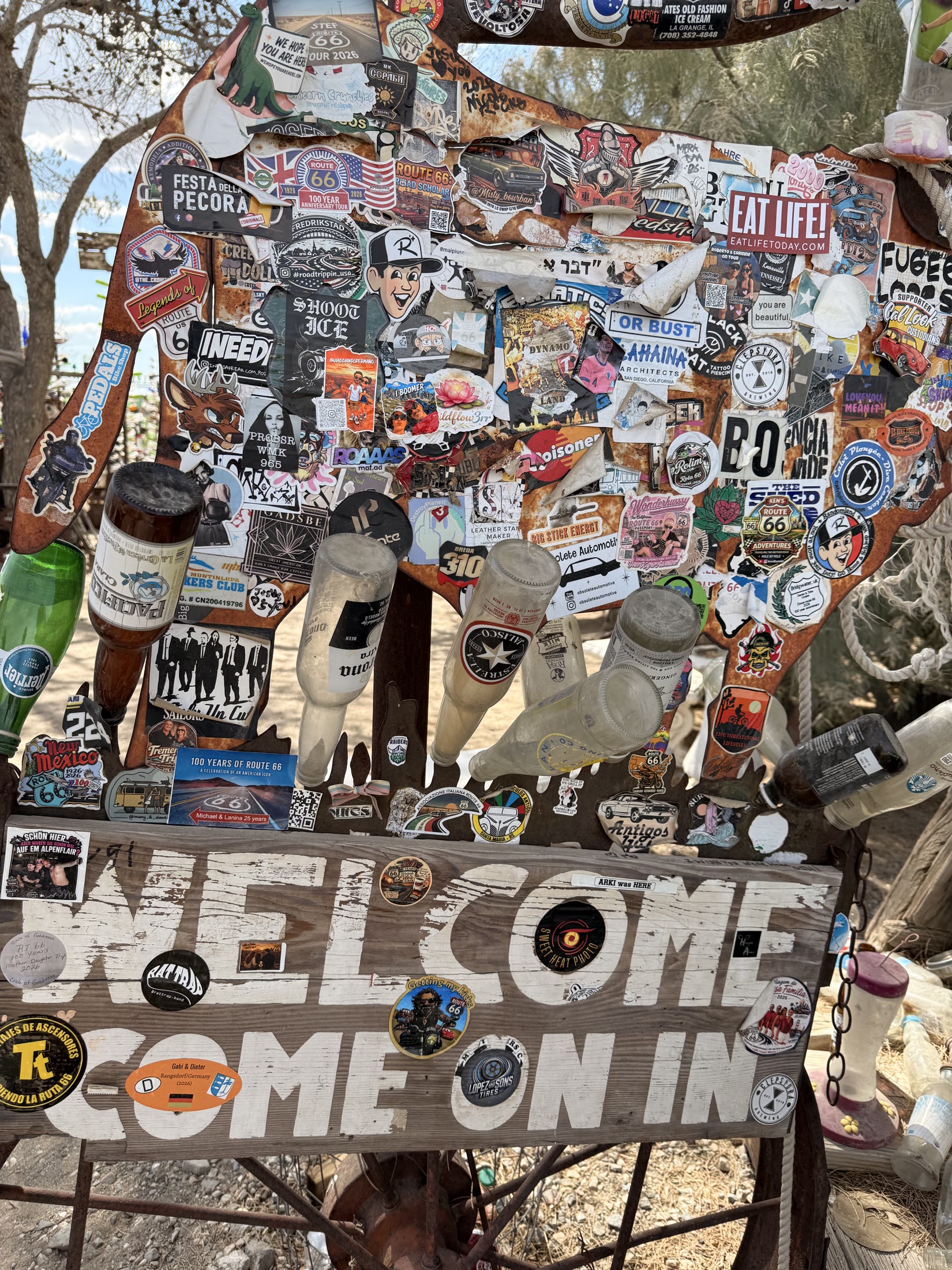 A colorful welcome assembled from signs, stickers and roadside relics.