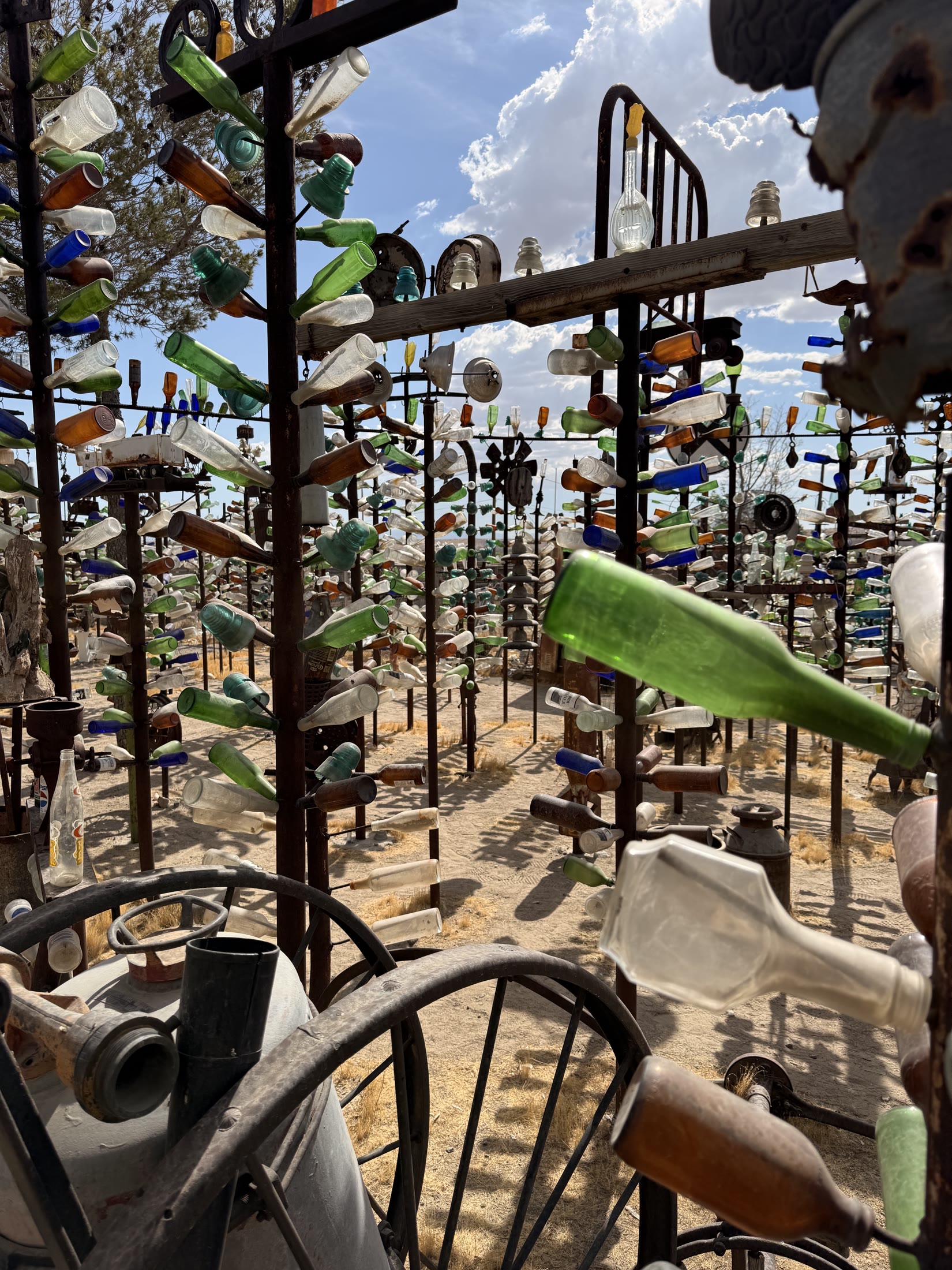 Glass bottles and found objects transformed into roadside art.
